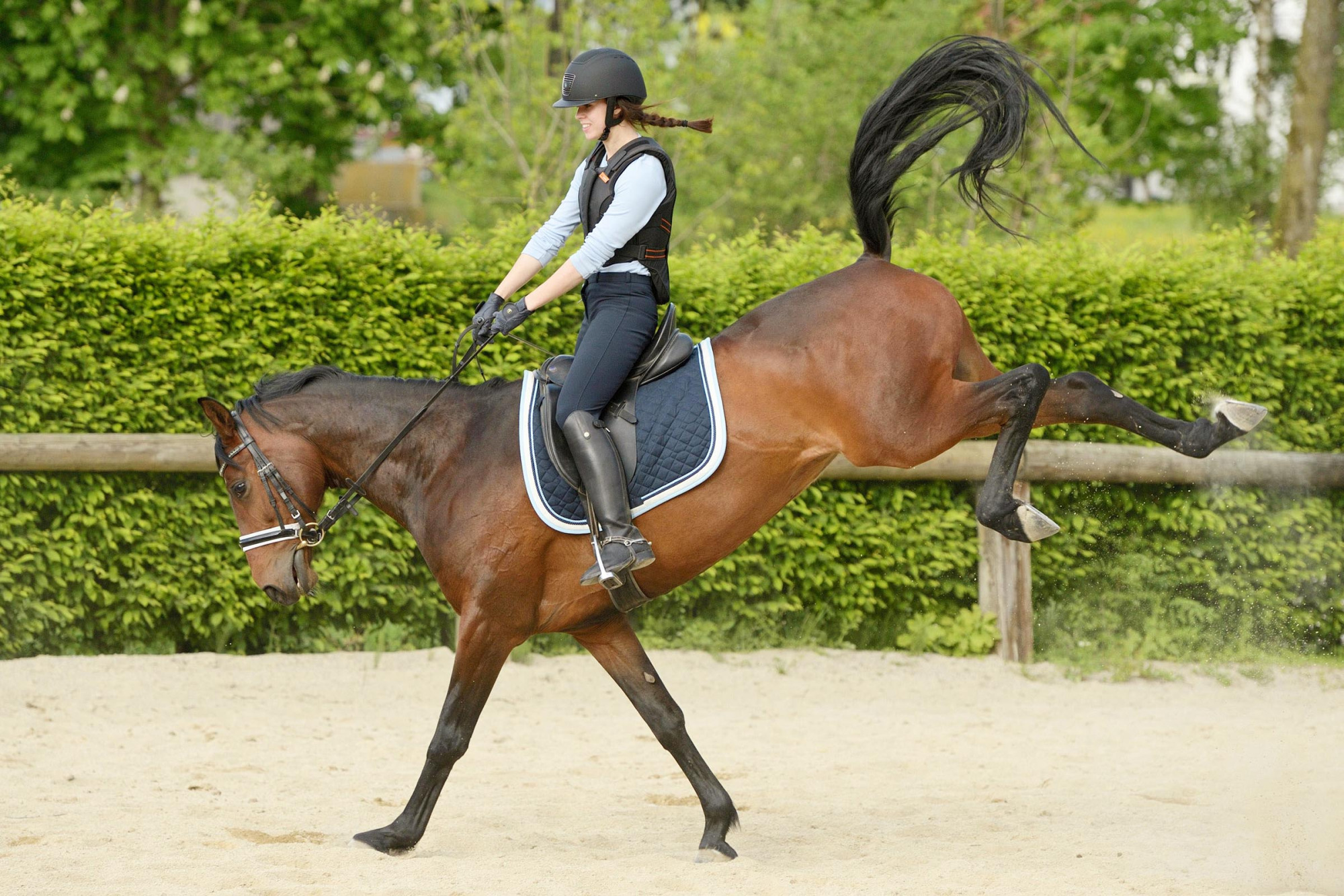 Young Rider Wearing A Body Protector On Back Of A Bucking Horse
